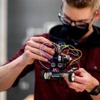 Student tweaking their mini self driving toy car